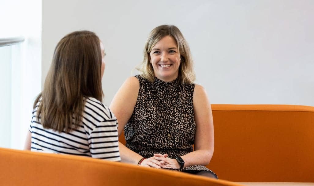 Two people laughing on a sofa at AAB