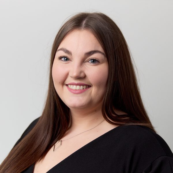 An image of Alyson Watson wearing a black top and smiling at the camera.