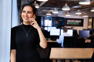 Woman in an AAB office speaking on a mobile phone