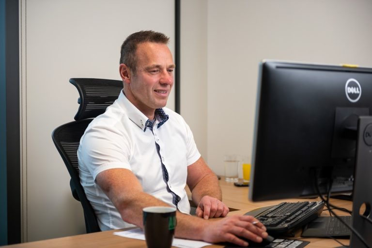 An employee on a computer in an AAB office.