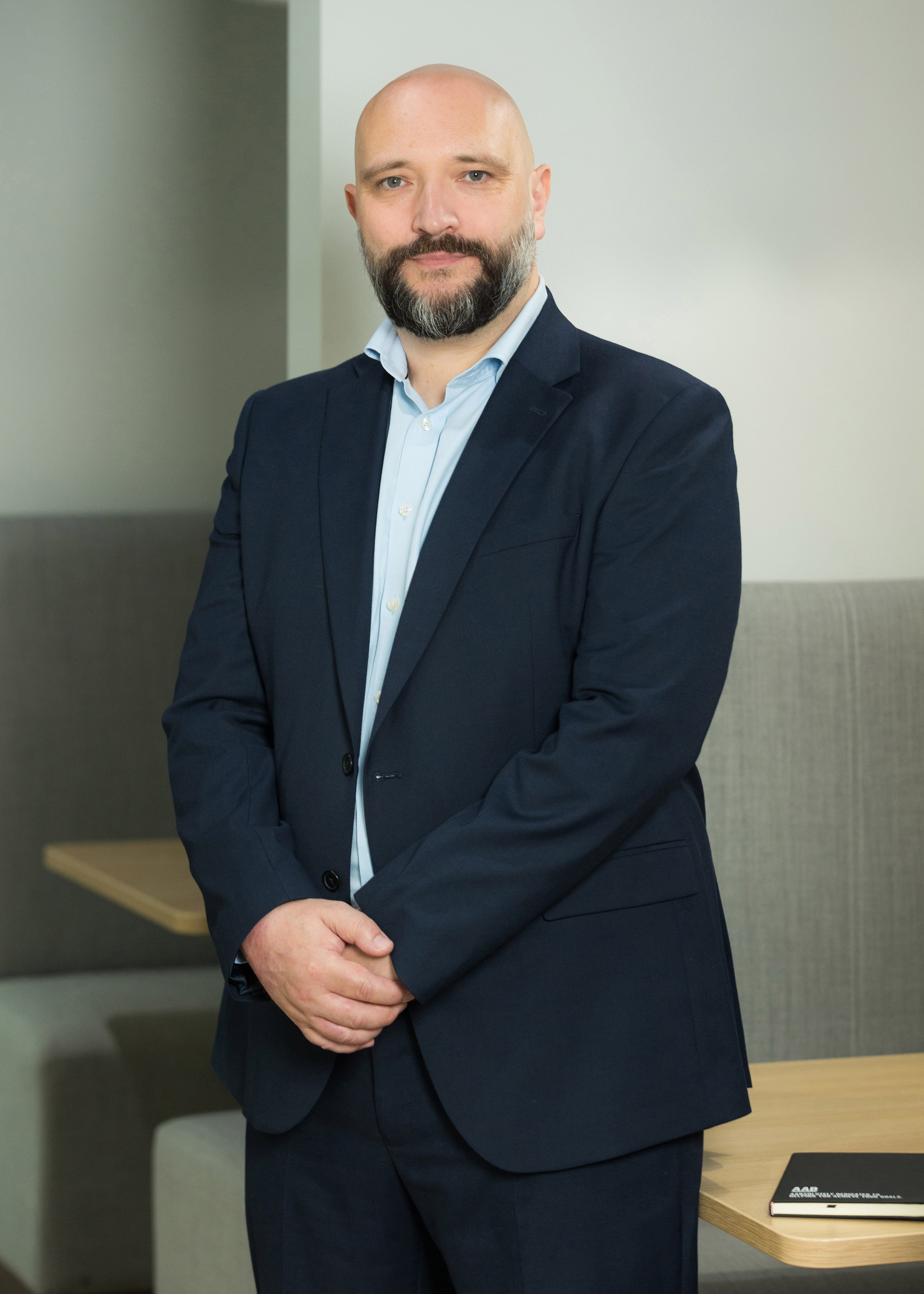 An image of Ross Parsler standing in the office wearing a suit.