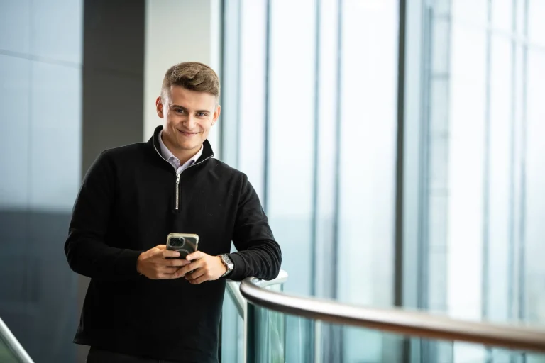 AAB team member smiling with phone.