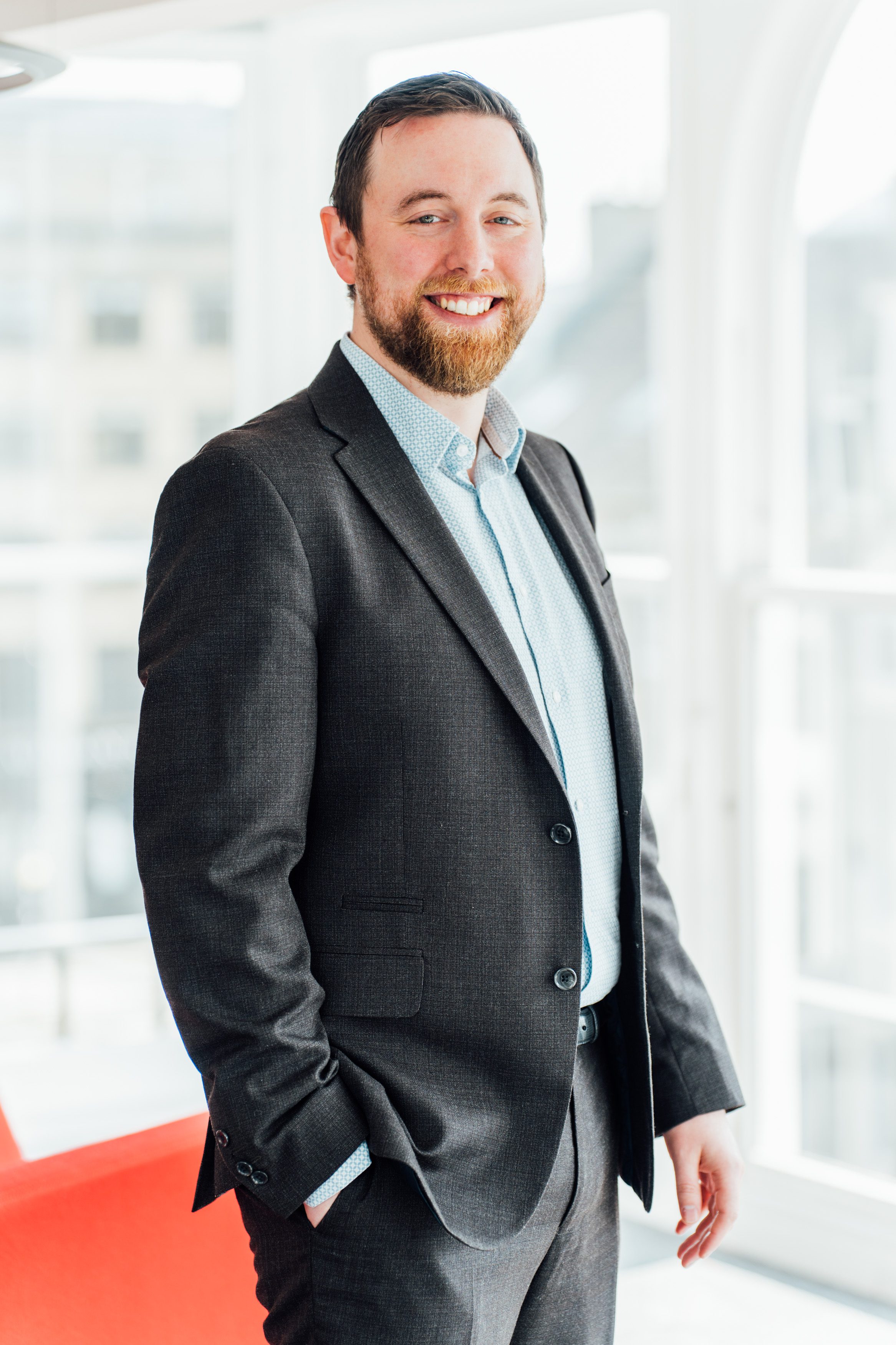 An image of Chris Webster standing next to a video and smiling.