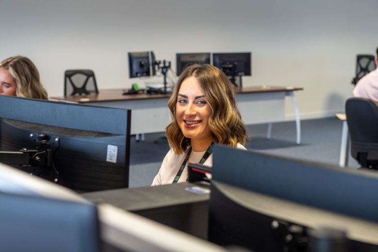 AAB team member sitting at desktop in office.