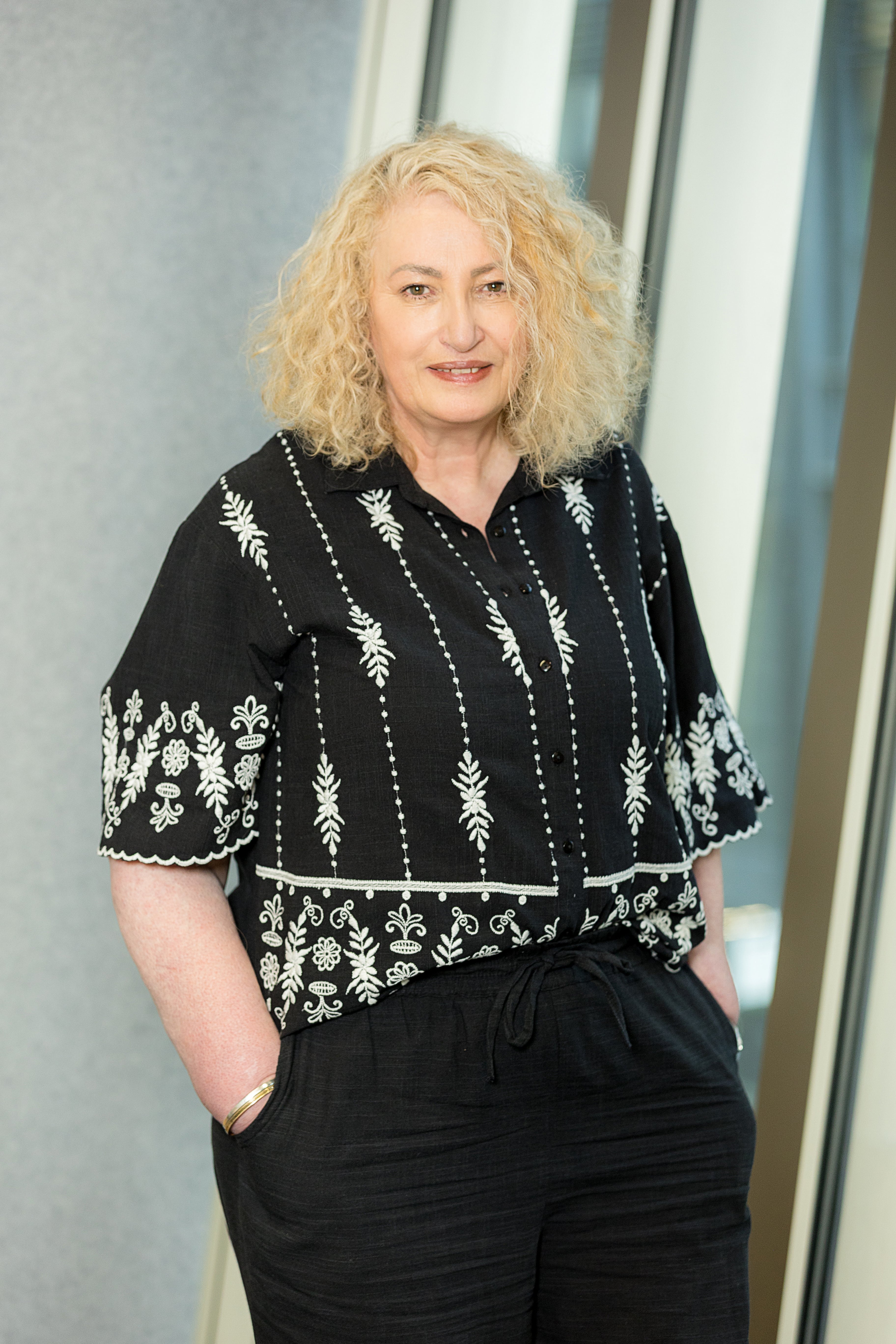 An image of Melanie Chart smiling at the camera with her hands in her pocket.