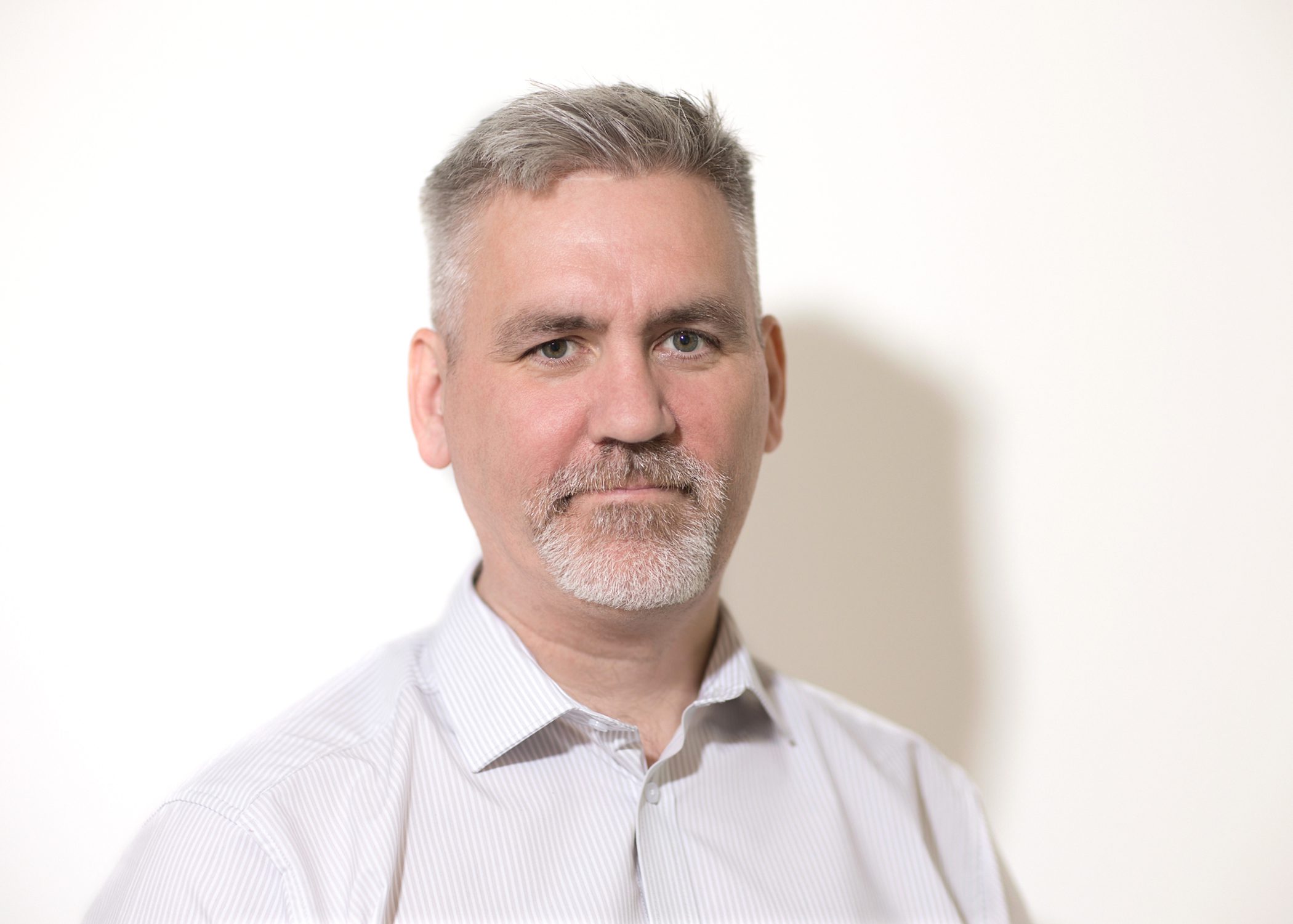 A headshot image of Sean McAuley smiling at the camera.
