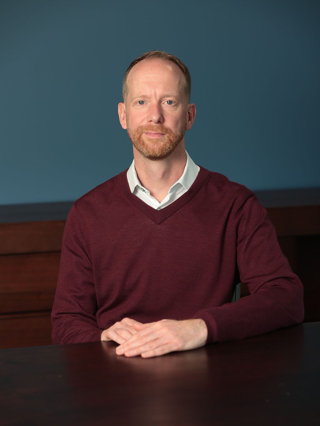 An image of Jamie Stanford sitting at a desk and looking at the camera.