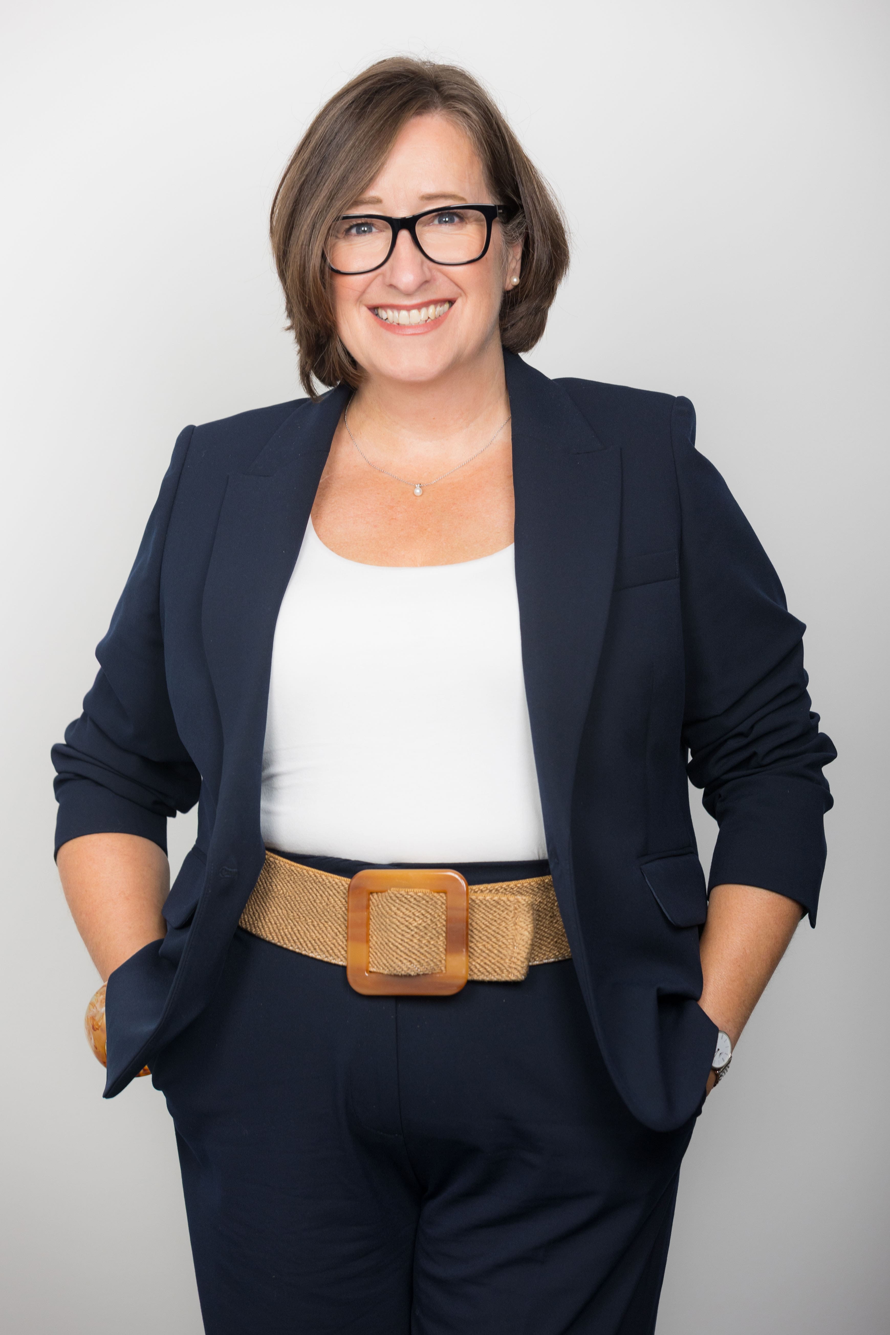 An image of Sharon Taylor standing with her hands in her pocket and smiling at the camera.