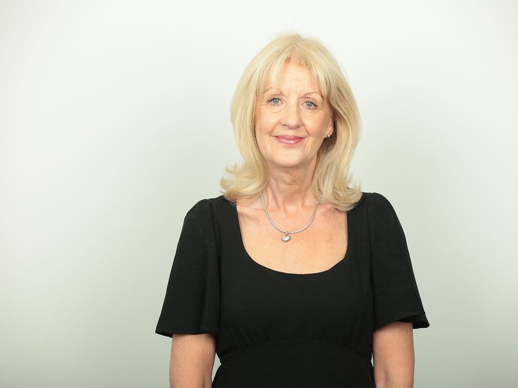 An image of Tracey Thorpe wearing a black top and smiling at the camera.