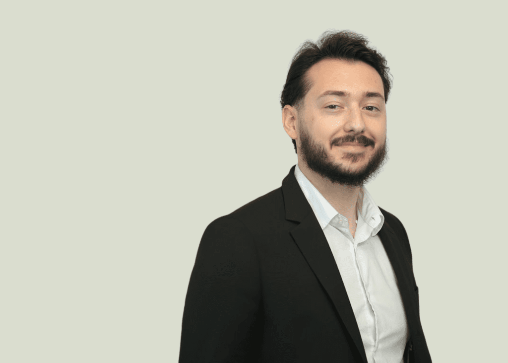 A headshot image of Belmin Hadzic wearing a suit and white shirt.