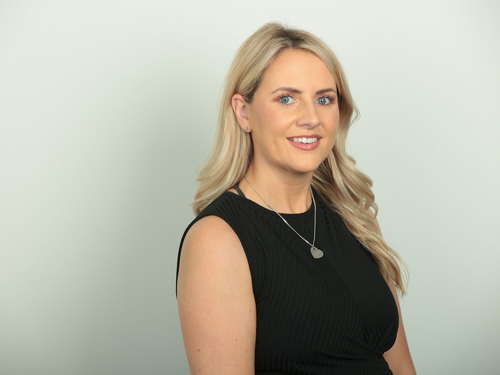 An image of Lianne Finnegan wearing a black dress and smiling at the camera.