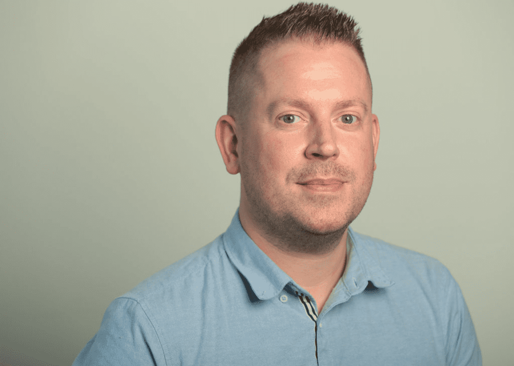 An image of David Felton wearing a blue shirt and smiling at the camera.