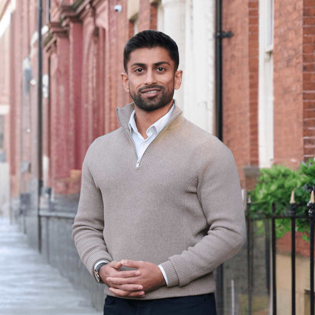 An image of Abdullah Daji wearing a cream top and smiling at the camera.
