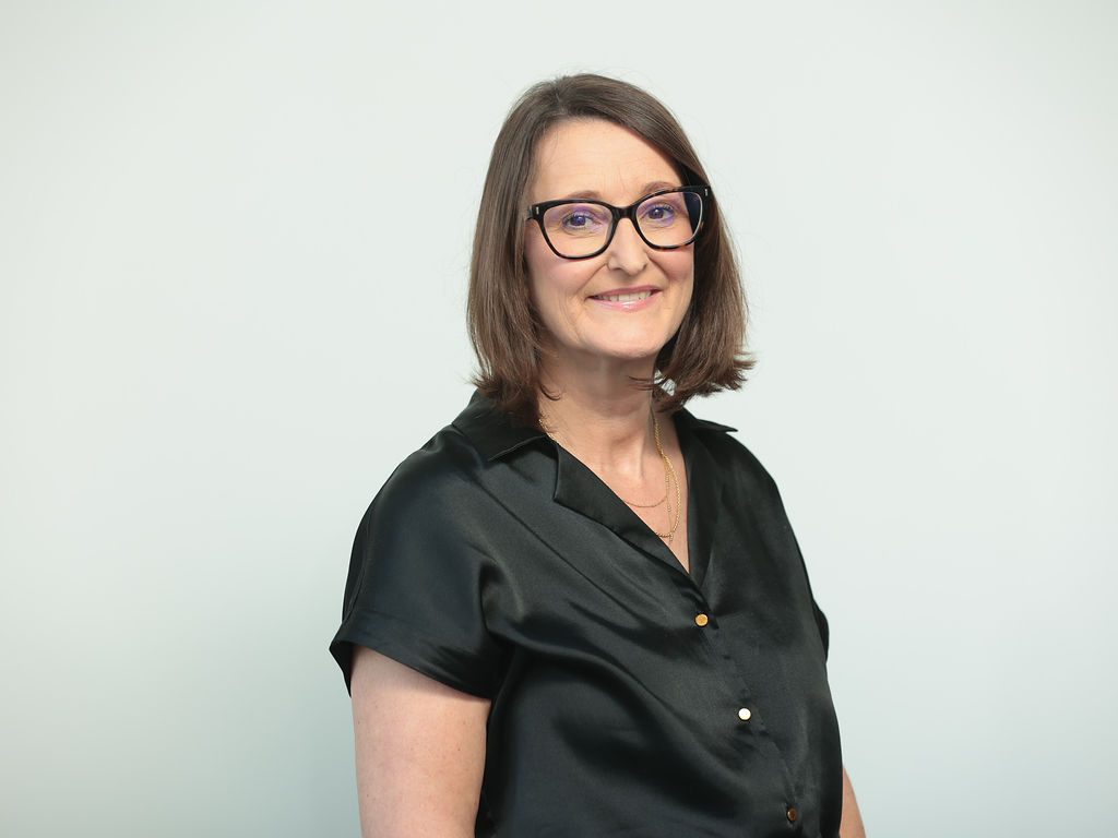 An image of Fran Powell wearing a black top and black glasses. She is smiling at the camera.