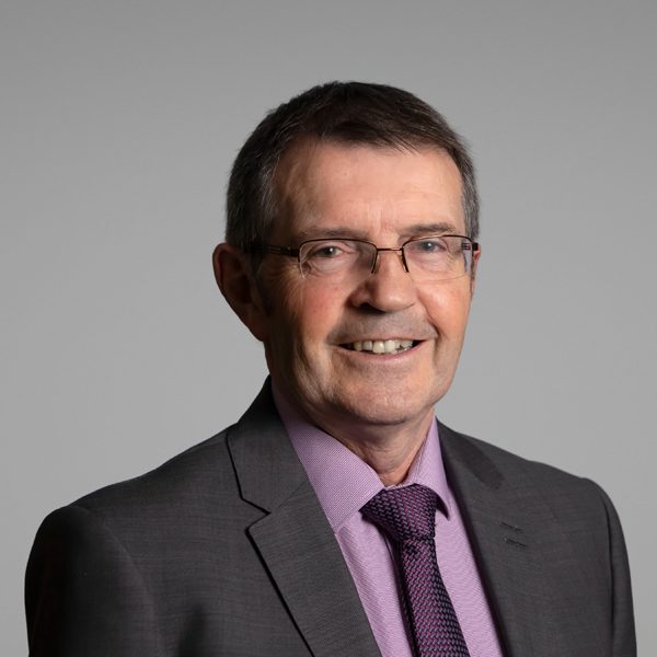 Michael J Smith in grey suit and yellow shirt.