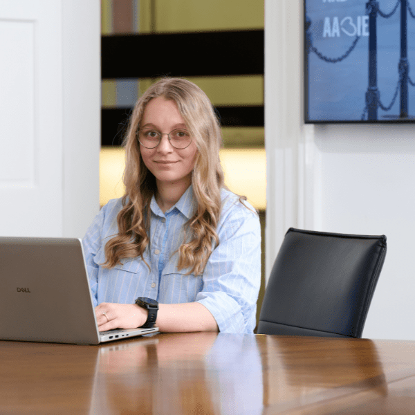 An image of Anna Piercy sitting at the desk on her laptop.