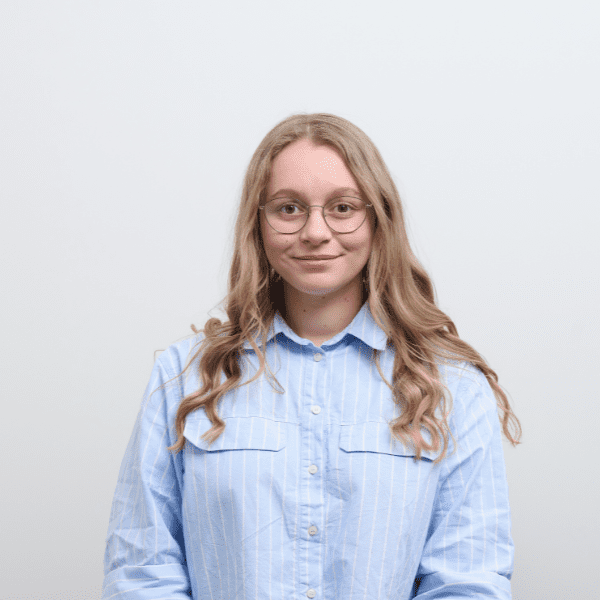 An image of Anna Piercy wearing a blue shirt and smiling at the camera.