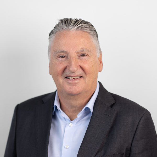 David Marsh smiling in suit jacket and blue shirt.