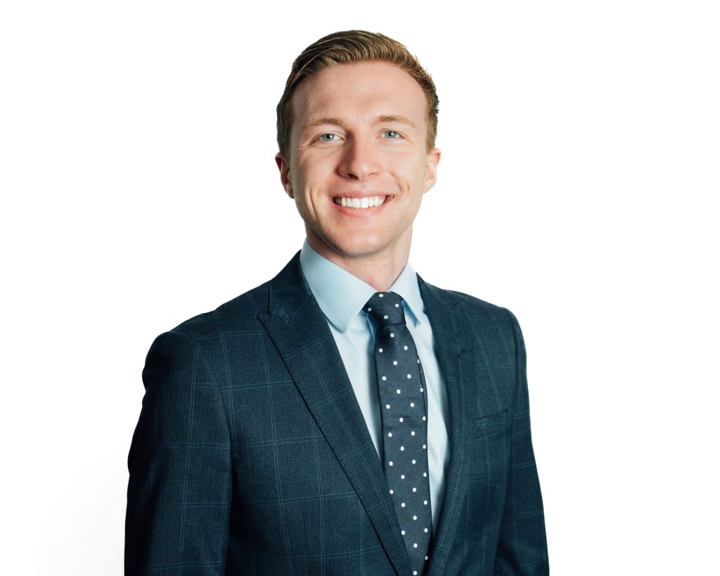 An image of Fraser Mackay wearing a suit and tie and smiling at the camera.