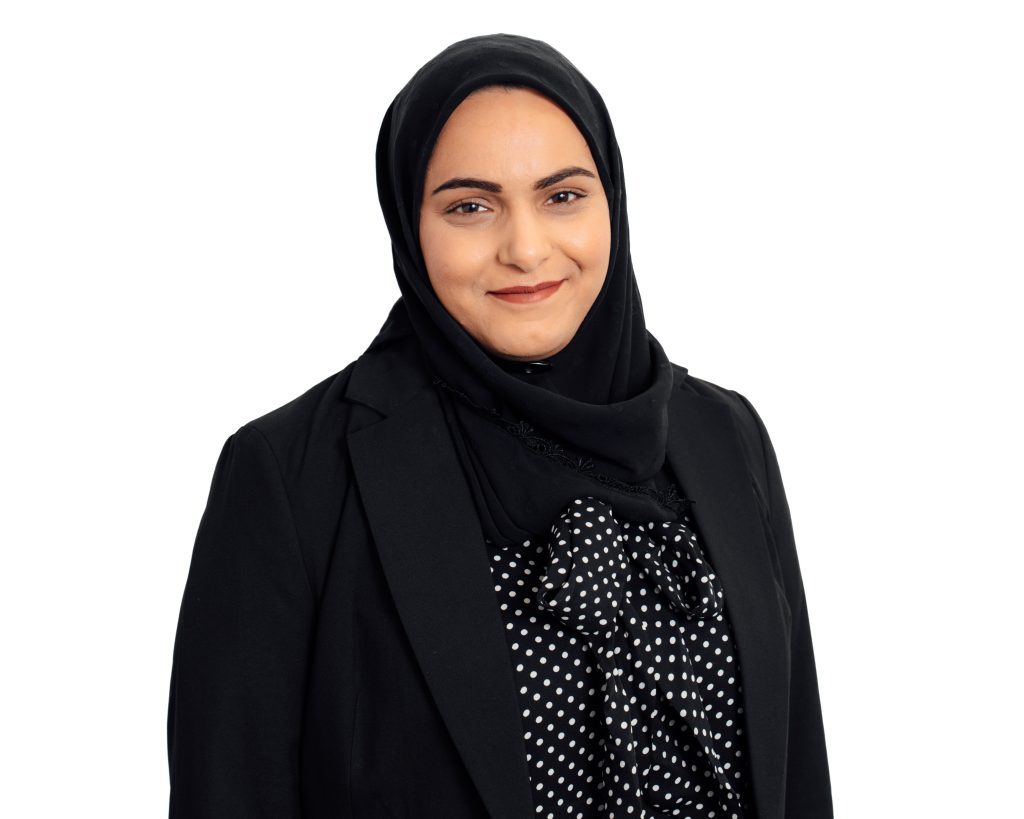 A headshot image of Aishah Akhtar. She is smiling at the camera.