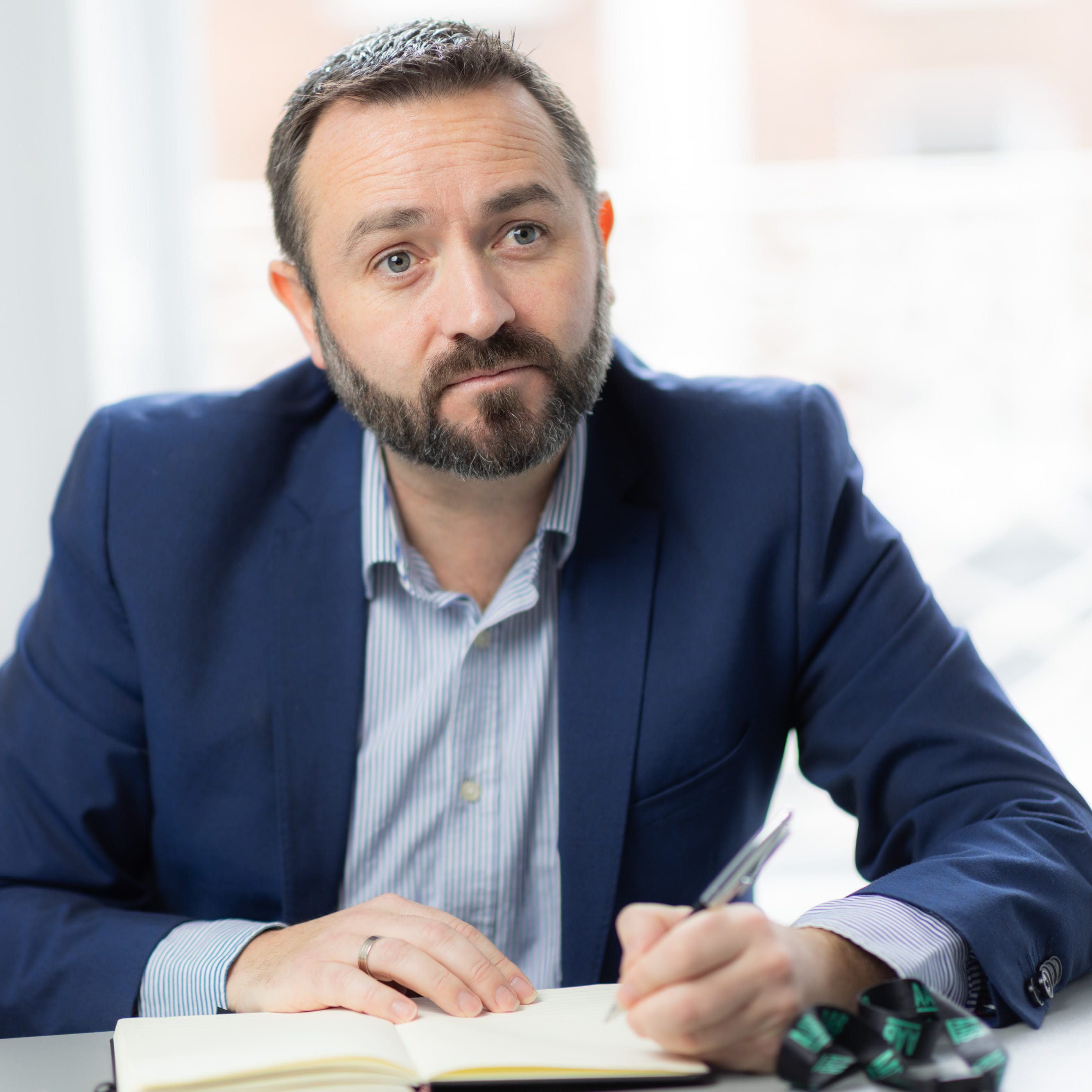 An image of Jonathan Fitzpatrick sitting at a desk writing in his AAB notebook.