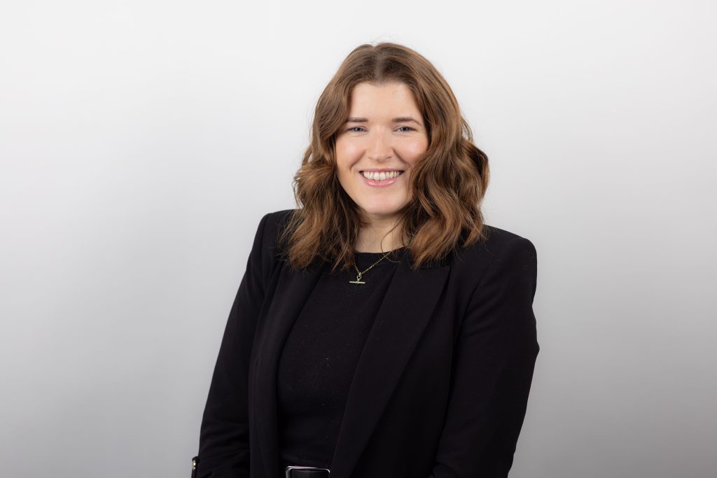 An image of Niamh Ryan wearing a black outfit and smiling at the camera.