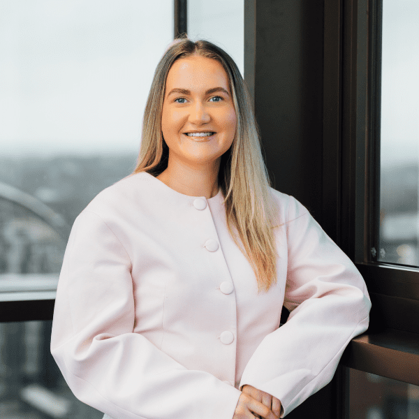 An image of Olivia Meldrum wearing a pink top and smiling at the camera.