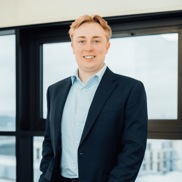 An image of Robbie Boyle wearing a shirt and blazer. He is smiling at the camera.