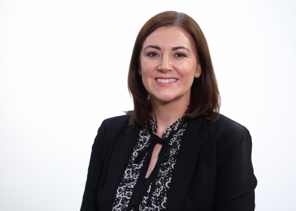 An image of Tanya O'Hare wearing a blazer and black top. She is smiling a the camera.