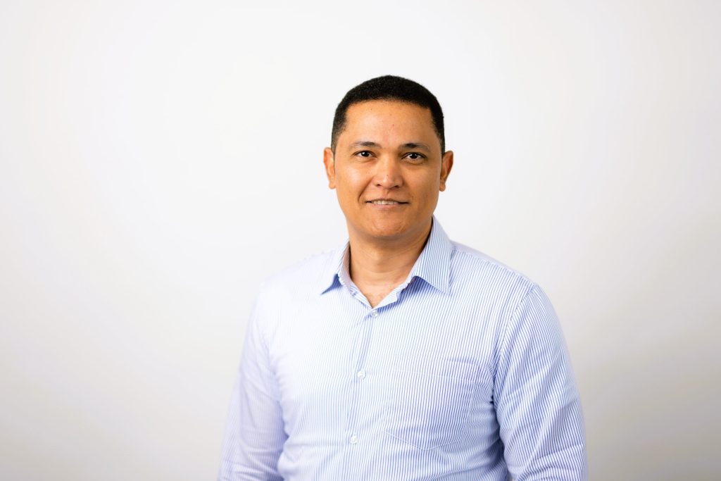 An image of Danys Orozco wearing a blue shirt and smiling at the camera.