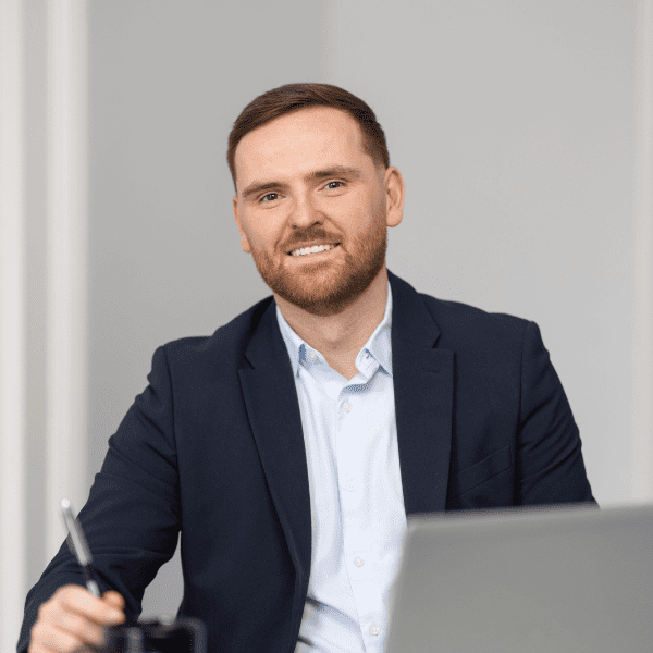 An image of Ronan Dunne sitting at a desk with his laptop.