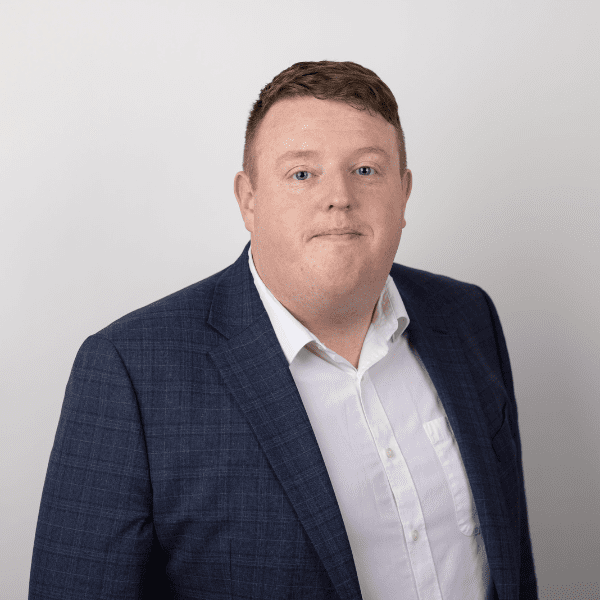 An image of Paul Giblin wearing a white shirt and blue suit jacket.