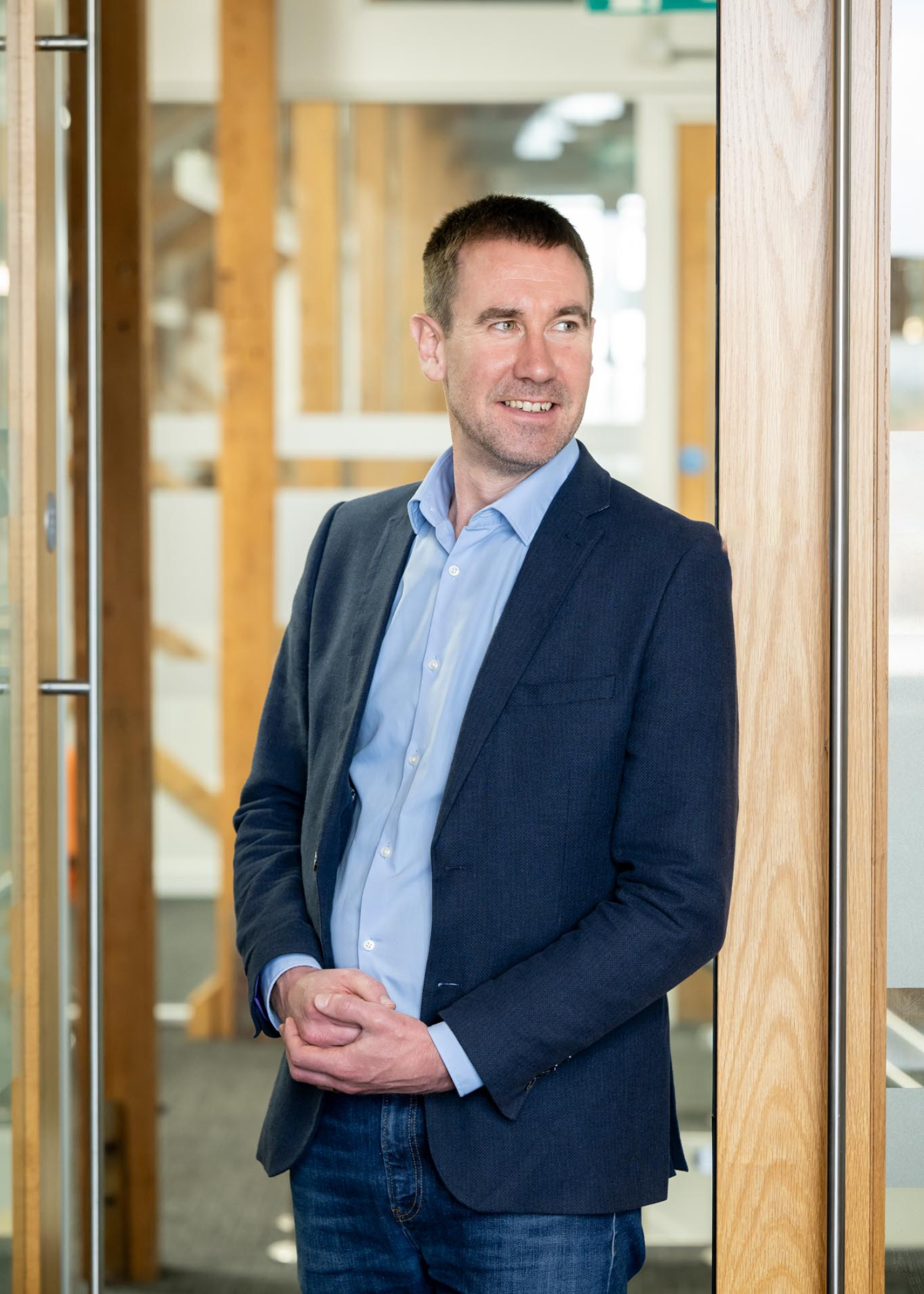 Matt Sutton Law Partner looking to the right side and stood in a doorway in an office setting