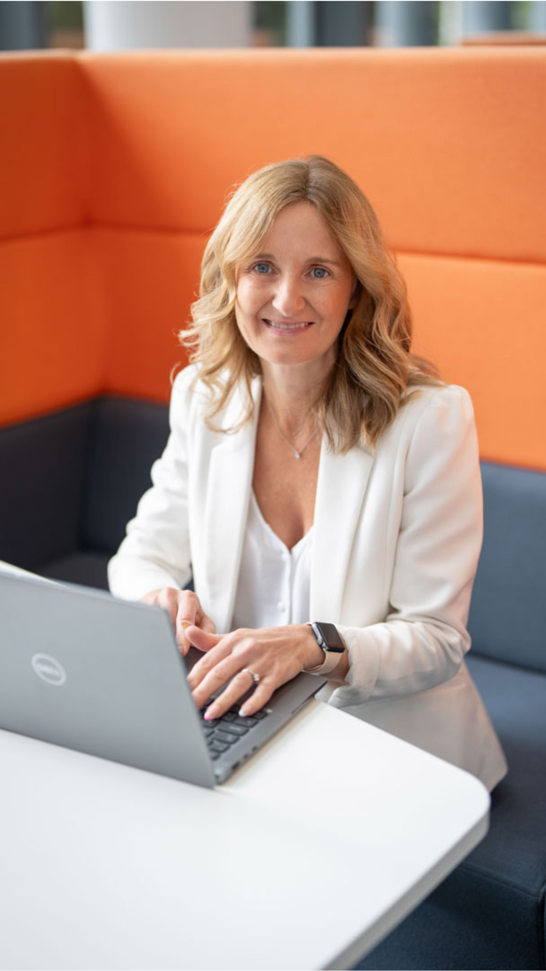 Zoe Lumsden sitting in a booth on a laptop