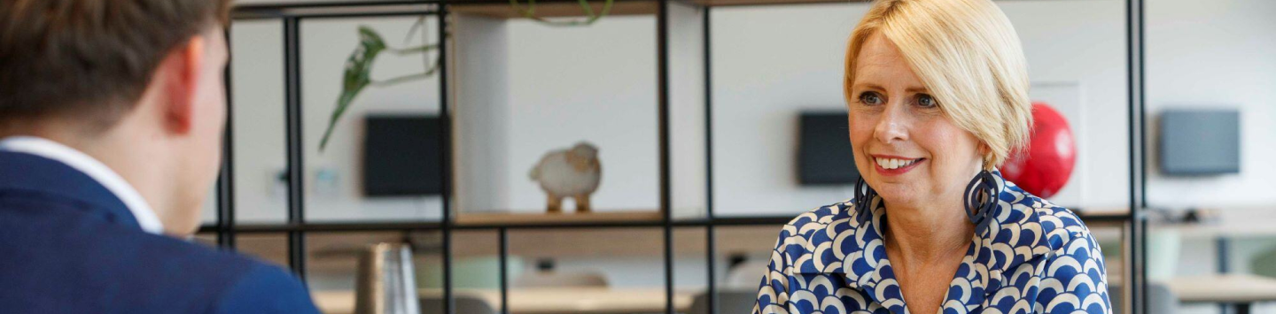 An image of Julie smiling at the colleague in the office.