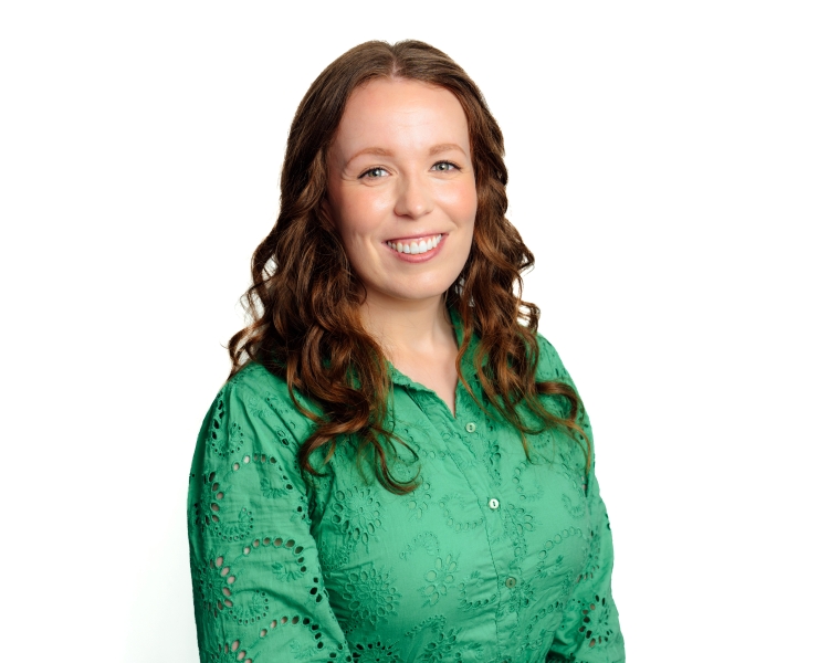 Sabelle Groves head and shoulder shot smiling against a dust coloured background